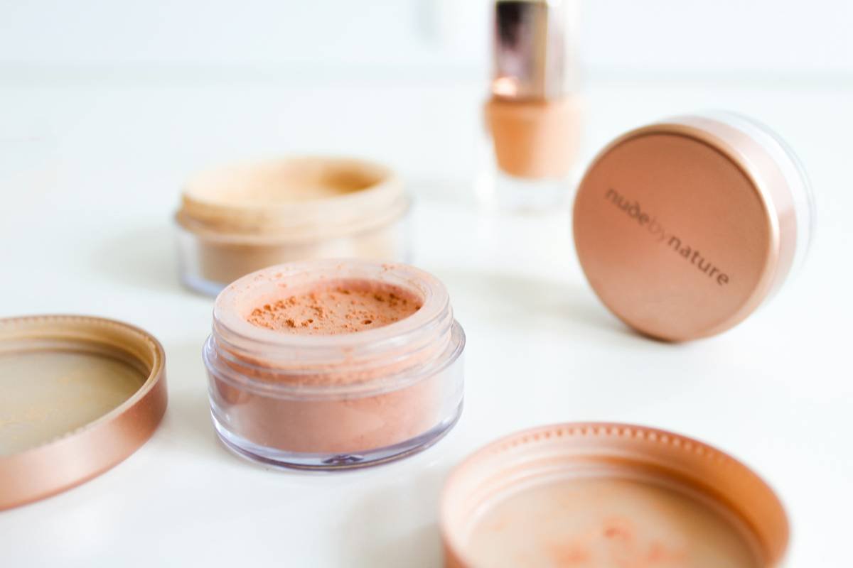 Infographic showing how makeup hold spray creates a polymer film over skin and makeup layers to lock in place