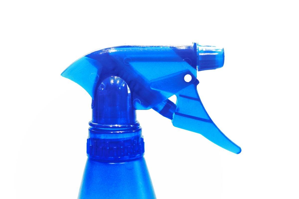 Woman gently misting setting spray for sensitive skin onto her face with eyes closed